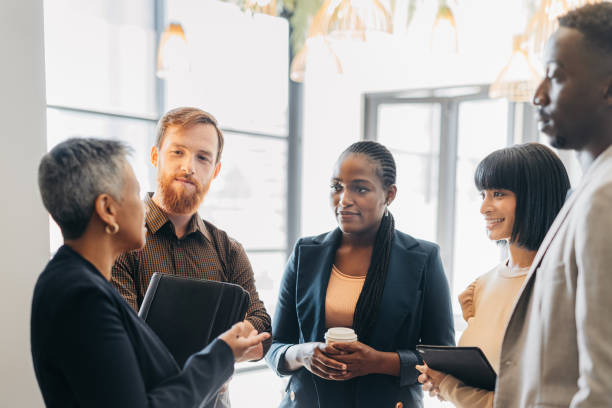 Female leader, manager or CEO in a meeting with her corporate team for planning, strategy and learning. Leadership, management and mentorship with a woman boss and her staff talking in the office stock photo