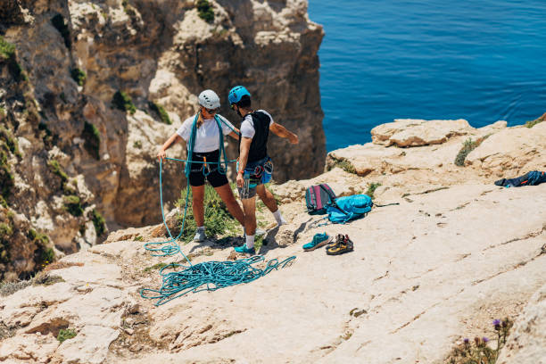 istock A male climber showing his female climbing partner how to secure her path with right using of the rope 1425880123