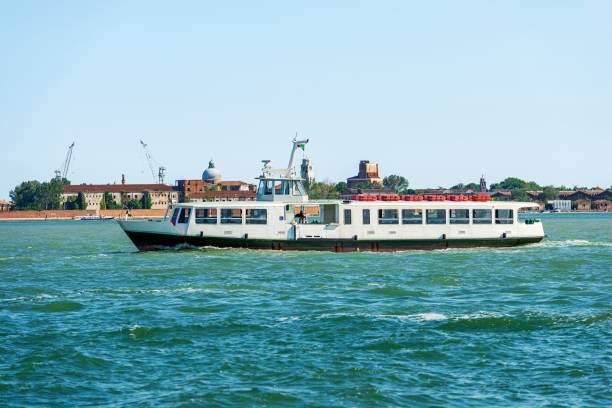 Empty white ferry or vaporetto in motion in the Venetian Lagoon on a sunny spring day. Venice, UNESCO world heritage site, Veneto, Italy, southern Europe.