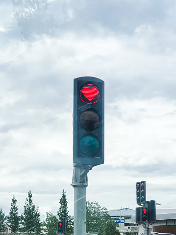 Hearts of Akureyri Traffic light, Main Ring Road through Akureyri, Iceland, June 30, 2022 - a traffic light with a heart symbol because of stickers on the stop sign.