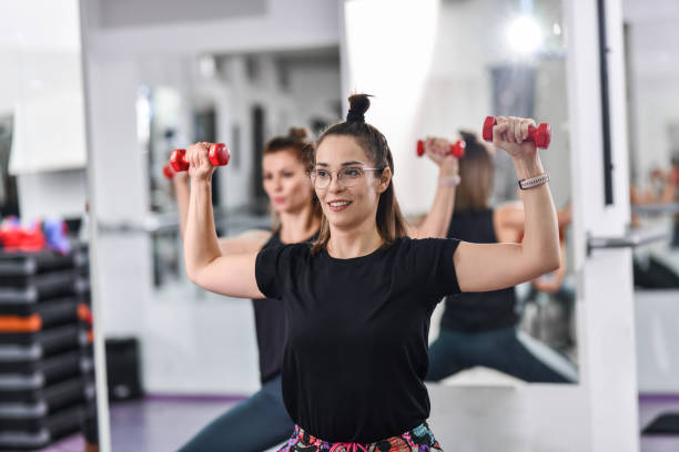 istock Female With Glasses Enjoying Workout Group Routine With Dumbbells 1425884804