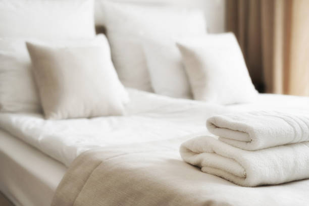 toallas blancas y limpias en la cama en la habitación del hotel - queen size bed fotografías e imágenes de stock