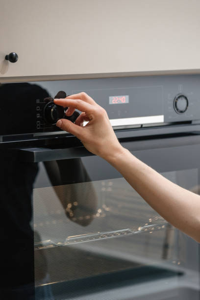 istock Woman turn setting button on built-in electric oven 1425889070