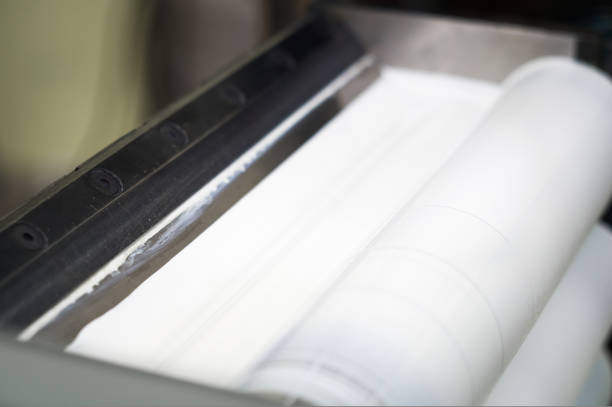 istock White ink in the paint system compartment of a modern flexographic printing press in a print shop. White paint in the ink feeder on the printing cylinder. Selective focus 1425890537