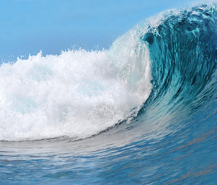 Strong ocean wave breaking in front of dark clouds