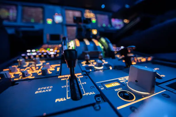 Pictures of a night flight of an Airbus 320 inside the cockpit. Different focus points of the instruments. On the right side the trim wheel and straight ahead the communication panel.