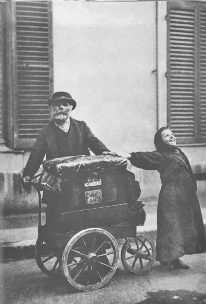 istock Paris, 1898, senior organ grinder with girl 1425898472