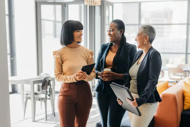 Photo of Business women in meeting conversation at digital marketing agency company for empowerment, motivation and tech innovation. Corporate worker people talking of social media trends at informal office