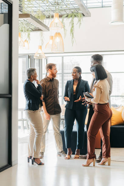 unternehmensteam und führungskraft sprechen in der unternehmenslounge über ein kreatives kollaborationsprojekt. vielfalt, mitarbeiter und fachleute planen ein treffen im büro. arbeitsfreunde, die ein gespräch führen. - color image image vertical people stock-fotos und bilder