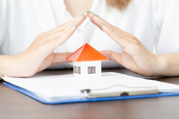 young woman use two hand to protect house model. real estate, insurance and property concepts