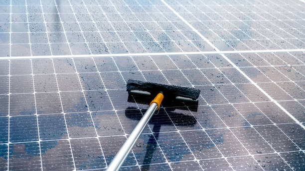 istock Cleaning solar panel with microfiber mop on wet roof. Solar panel or photovoltaic module maintenance service. Sustainable resource. Solar power. Green energy. Sustainable development technology. 1425901675