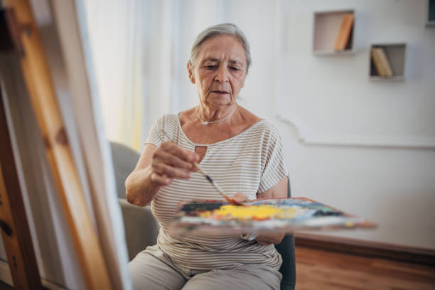 istock Mature female painter enjoying while painting 1425907268