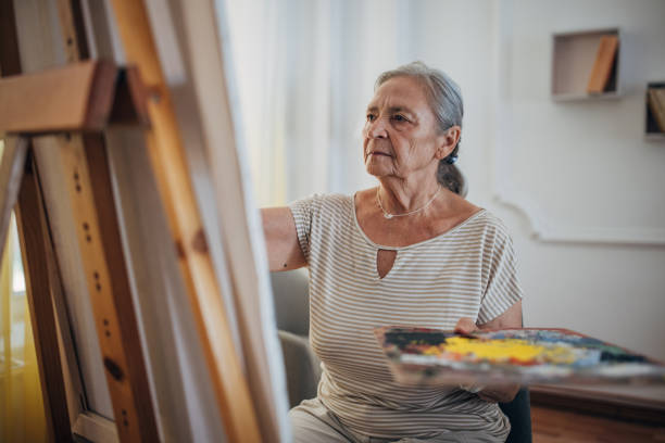 Mature female painter enjoying while painting