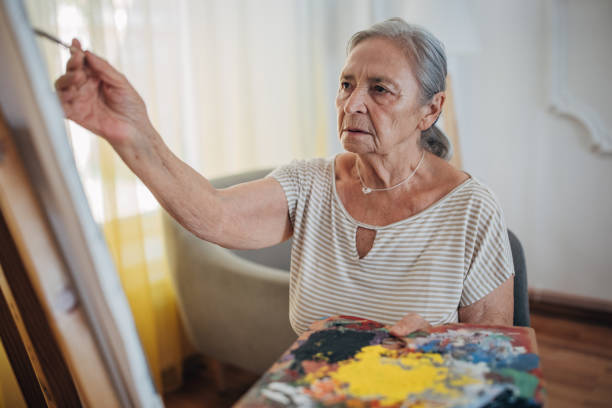 istock Mature female painter enjoying while painting 1425907351