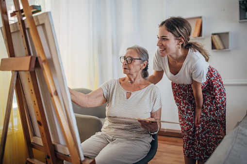 Grandmother painting with her granddaughter at home
