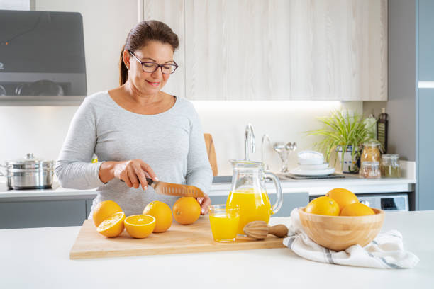 istock Mature woman preparing fresh juice in kitchen 1425914315