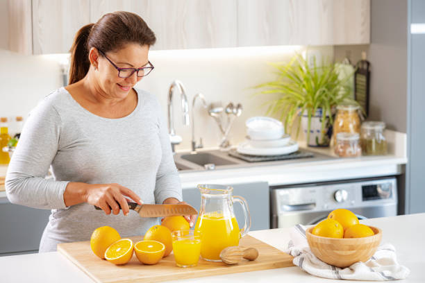istock Woman cutting fresh oranges to squeeze juice 1425914343
