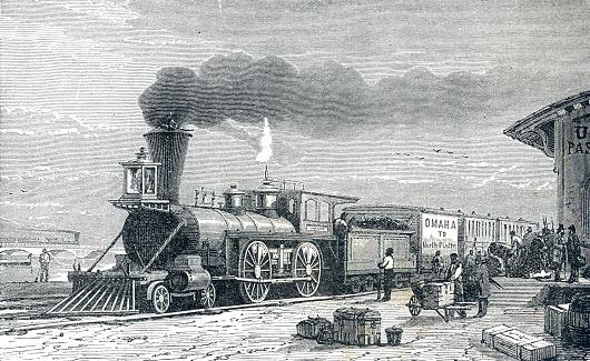 A locomotive engine car coal and smoke in Nebraska with passengers waiting on the station. In 19th Century