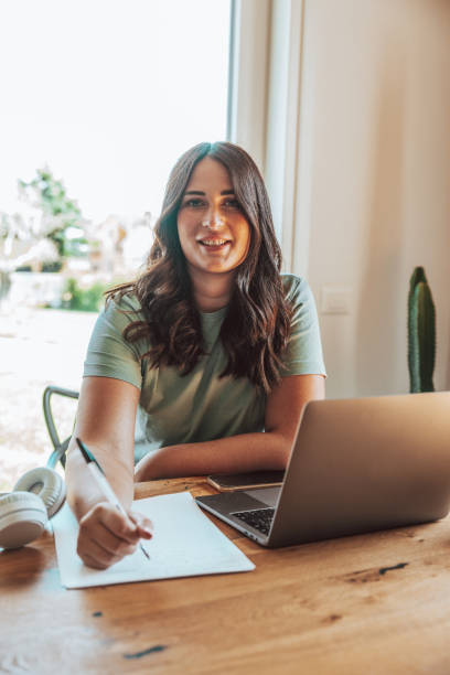 istock Smiling young woman sitting in her office working 1425919058