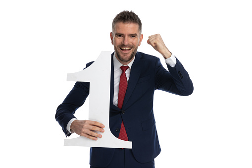 businessman celebrating the fact that he's number one with enthusiasm against white background