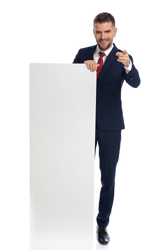 young businessman gesturing you where picked for the advertisement against white background