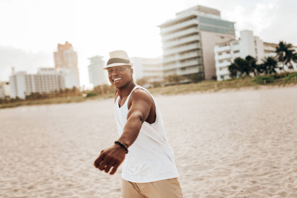 istock happiness afro man dancing on the beach 1425929513