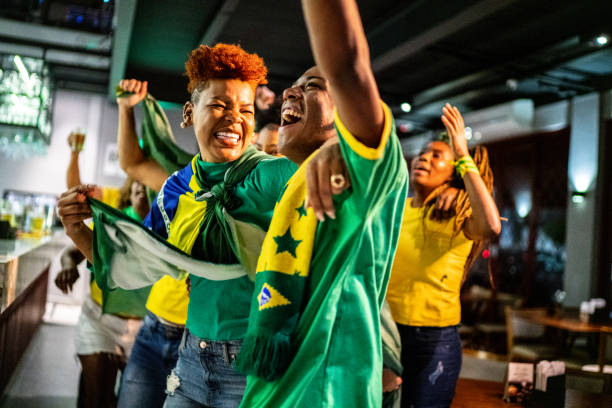 Brazilian sports fans watching match and celebrating at a bar Brazilian sports fans watching match and celebrating at a bar real symbol stock pictures, royalty-free photos & images