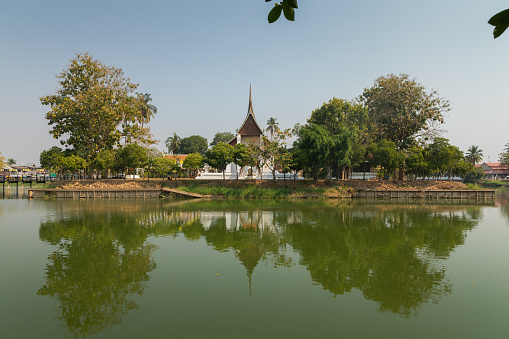 Landscape of the Wat Traphang Thong temple reflected in the water of the surrounding pond, at the Sukhothai Historical Park, Thailand