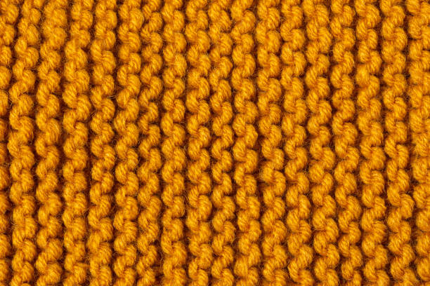 Knitted texture background. Hand-knitted wool. Knitted texture background. Hand-knitted wool. Macrophotography of a thread drawing. Orange pastel texture of sweaters, pullovers, cardigans. Abstract natural background. Comfort autumn warmth concept camel colored stock pictures, royalty-free photos & images