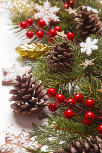 istock Christmas decoration. Christmas tree branches, red berries and snow flake shaped cookies on white background. 1425938029