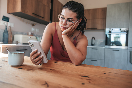 Woman checking phone in the morning having job problems.