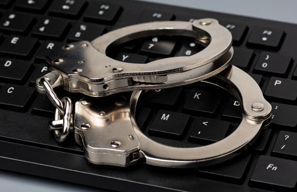 Computer keyboard and handcuffs. Cybercrime, internet security and crime concept. background, no people, closeup terrorist financing stock pictures, royalty-free photos & images