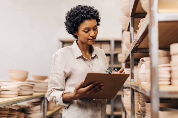 istock Female ceramic shop owner taking inventory in her store 1425945799