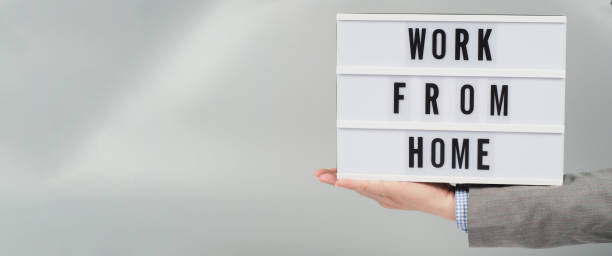 istock Hand and light box with word work from home on gray background. Wear grey suit. 1425948666