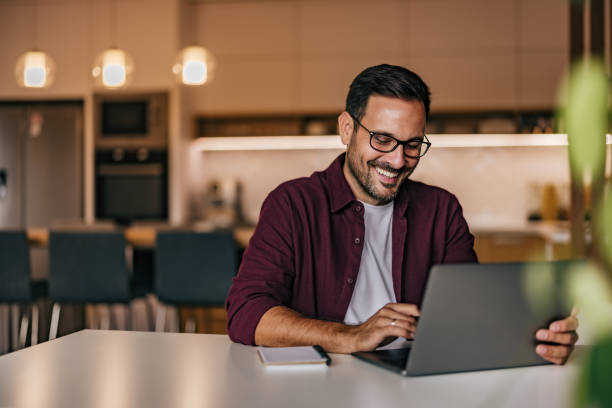 istock Happy businessman using a laptop, working over it, wearing glasses. 1425957988