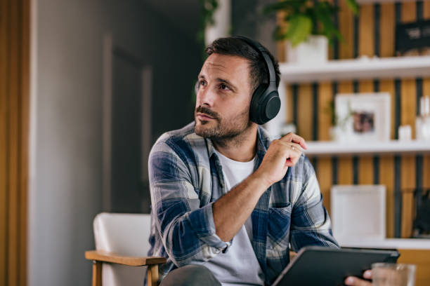 istock Businessmen looking on the side, listening to music, using a tablet. 1425958023