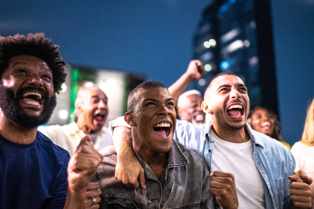 amateurs de sport regardant un match et célébrant sur le toit d’un bar - fan photos et images de collection