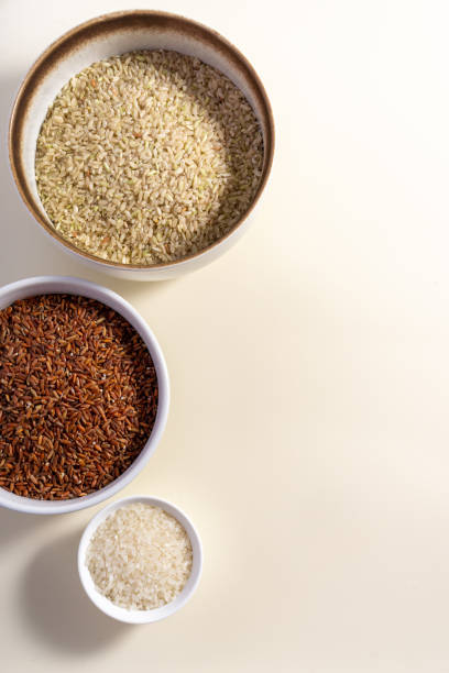 istock Uncooked rice assortment in bowl on white background. Top view. 1425962197