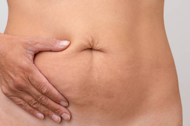 Hand on right side of stomach to show pain or symptom there Cropped woman hand on right side of stomach to show pain or symptom there female navel stock pictures, royalty-free photos & images