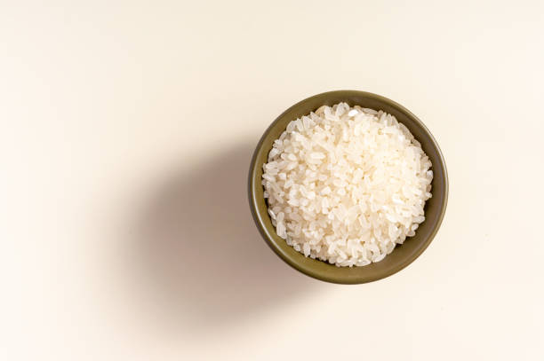 istock Raw rice assortment in bowl on white background. Horizontal. Place for text. Top view. 1425963058