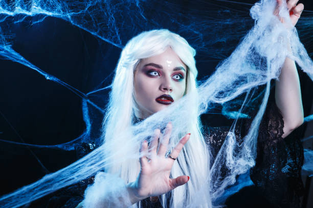 istock Halloween witch with long white hair wearing spider web. 1425970930