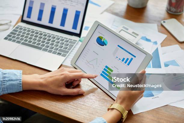 Businesswoman Analyzing Financial Graph On Digital Tablet Stock Photo - Download Image Now