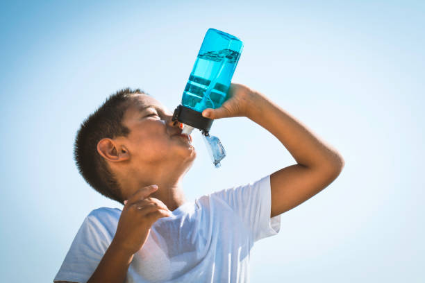 cute boy drinking water - water bottle water bottle drinking imagens e fotografias de stock