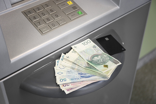 ATM and cash money. Euros withdrawal from an ATM machine, closeup view