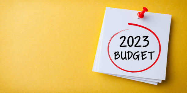 Budget 2023 Word in White Sticky Note on Yellow Chardboard Background stock photo