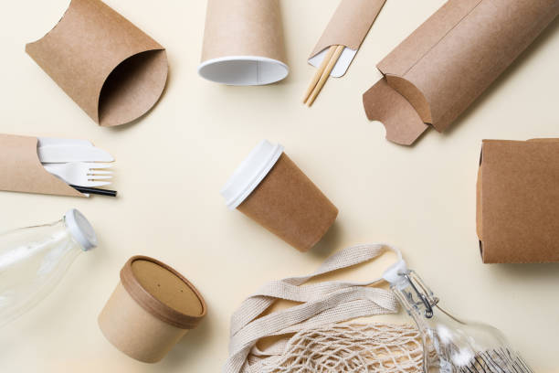 istock Eco-friendly packaging and utensils around a paper cup for coffee on a yellow background. The concept of ecology and zero waste. 1425987441