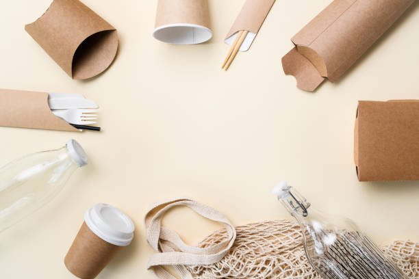 istock A set of disposable eco-friendly tableware and glass bottles around the empty space in the center of the frame. Free space for advertising. view from above. Zero waste concept 1425987880