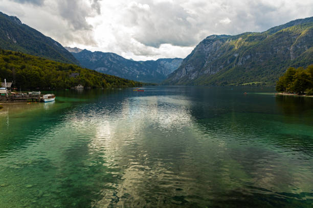 view over lake bohinj and the julian alps in slovenia - julian alps mountain lake reflection imagens e fotografias de stock