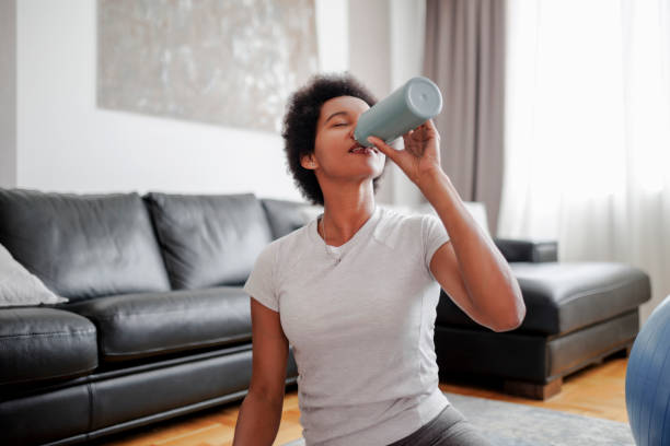 istock Mature black woman refreshment with water after intensive home workout 1425988400