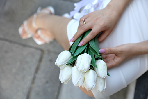 Bride hands with ring and wedding bouquet of flowers